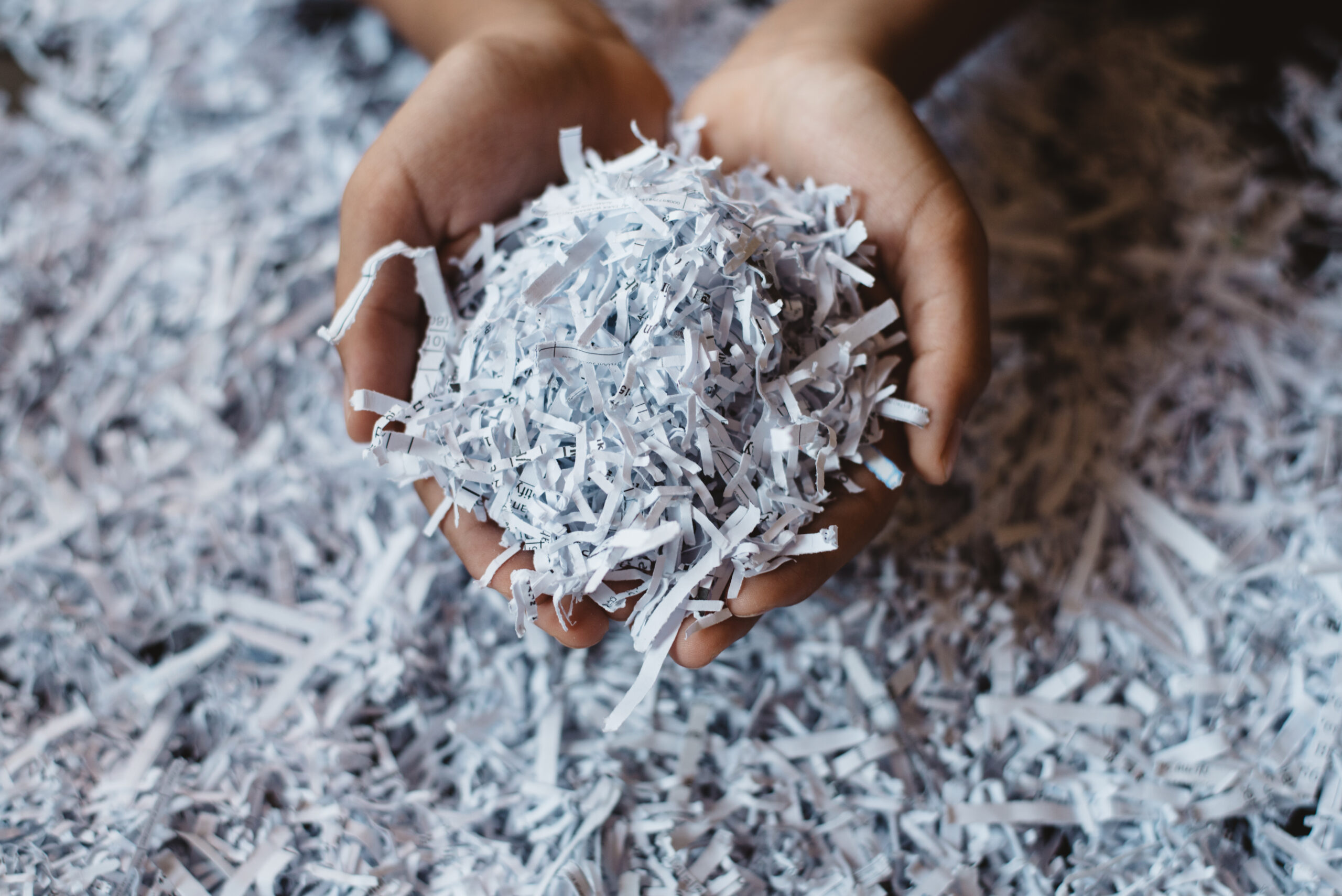 Hand,Showing,Heap,Of,Shredded,Paper.,Concept,Of,Recycle,And